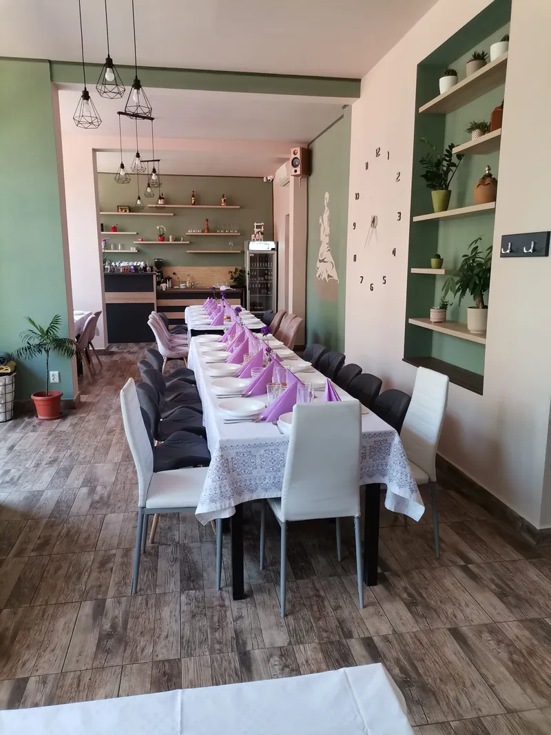 Sala verde, cu o masă lungă aranjată cu șervețele lila